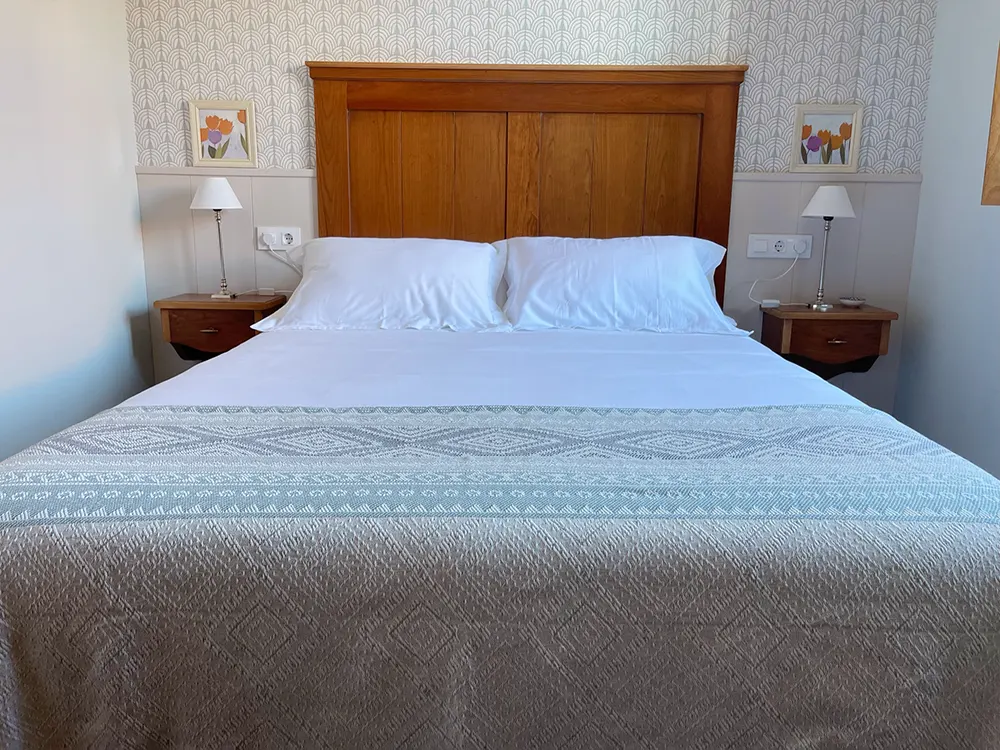 Cama doble con dos mesitas en la solana de mogro